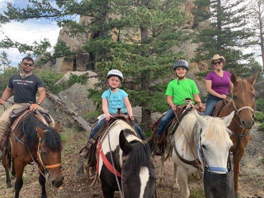 A family poses on horseback.