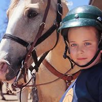 A child stands next to a horse