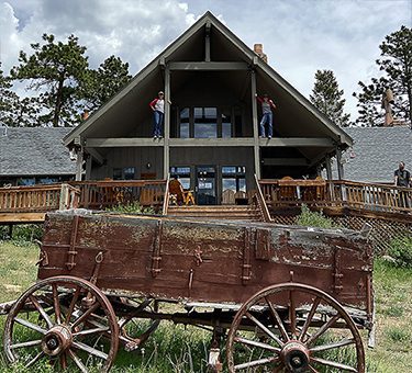 Two staff members pose up high on the lodge porch.