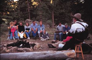 Guests sit around the campfire