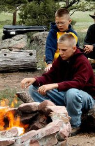Two boys sit in front of the fire
