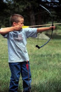 A boy shoots a bow and arrow