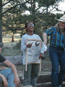 A child plays a washboard by the campfire