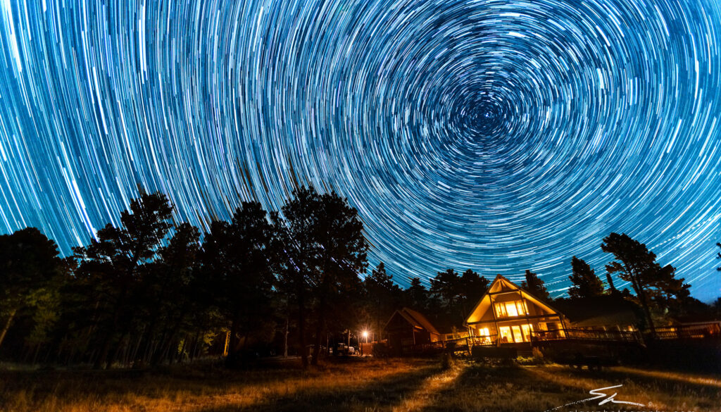 Star trails swirl above the main lodge at Sundance Trail Guest Ranch, capturing the beauty of the Colorado night sky.